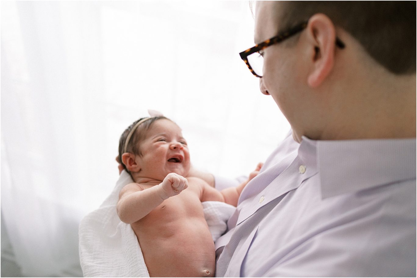 Baby girl smiling at her Dad during newborn session. Photo by Lindsay Konopa Photography.