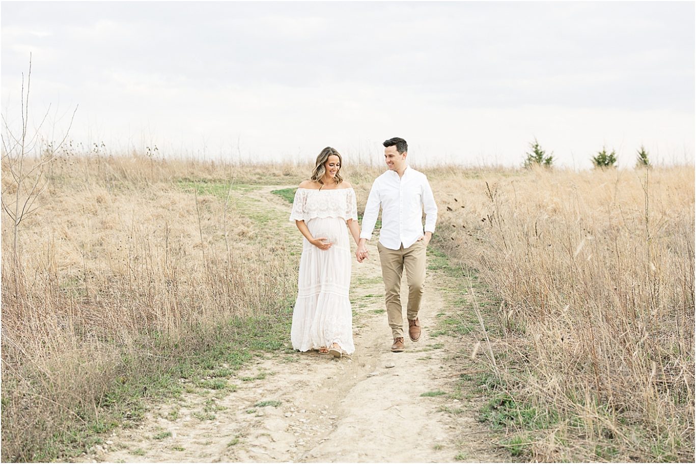 Parents to be walking through a field for maternity session with Lindsay Konopa Photography in Broad Ripple IN.