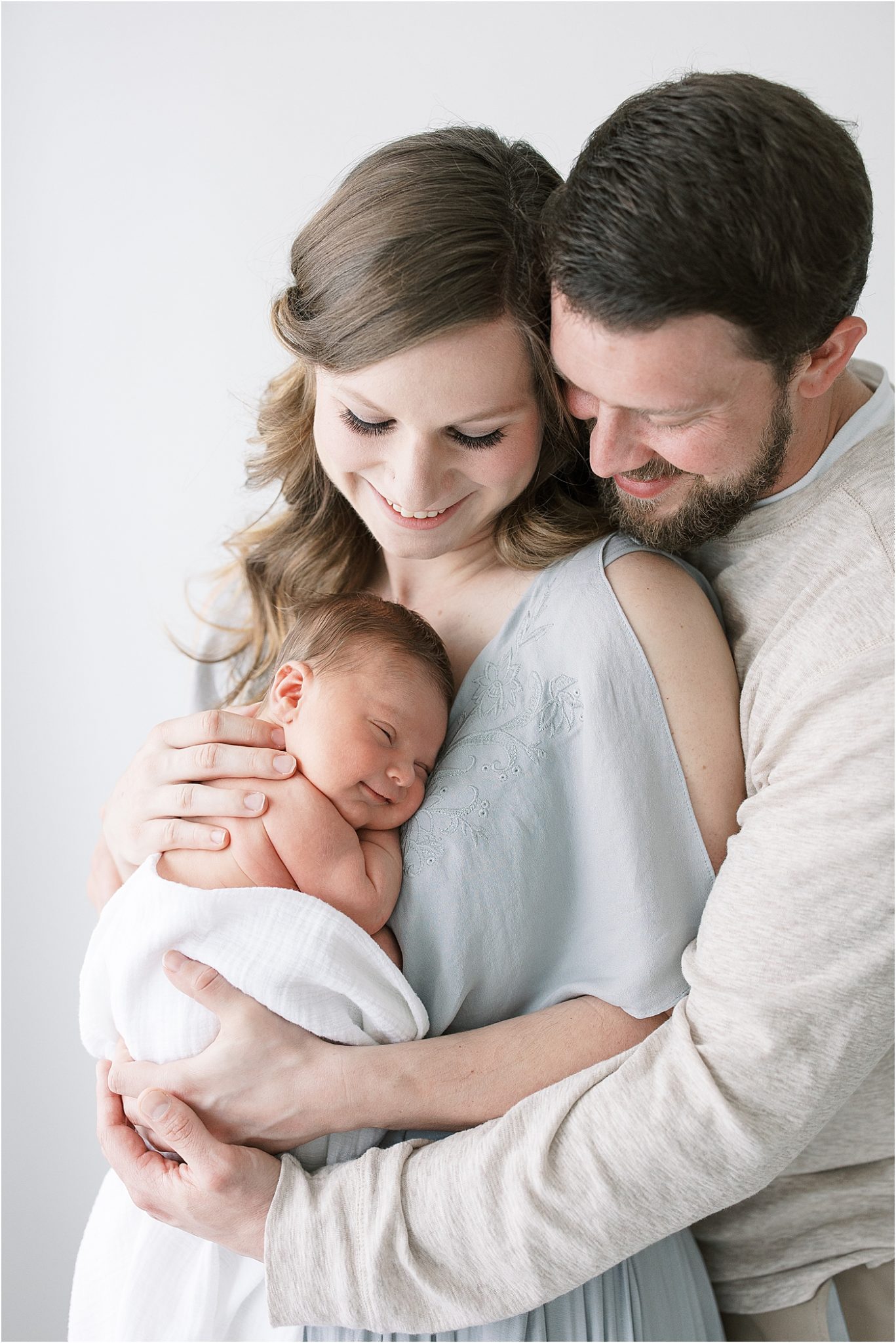 Mom and Dad snuggling their new baby boy.Photo by Lindsay Konopa Photography.
