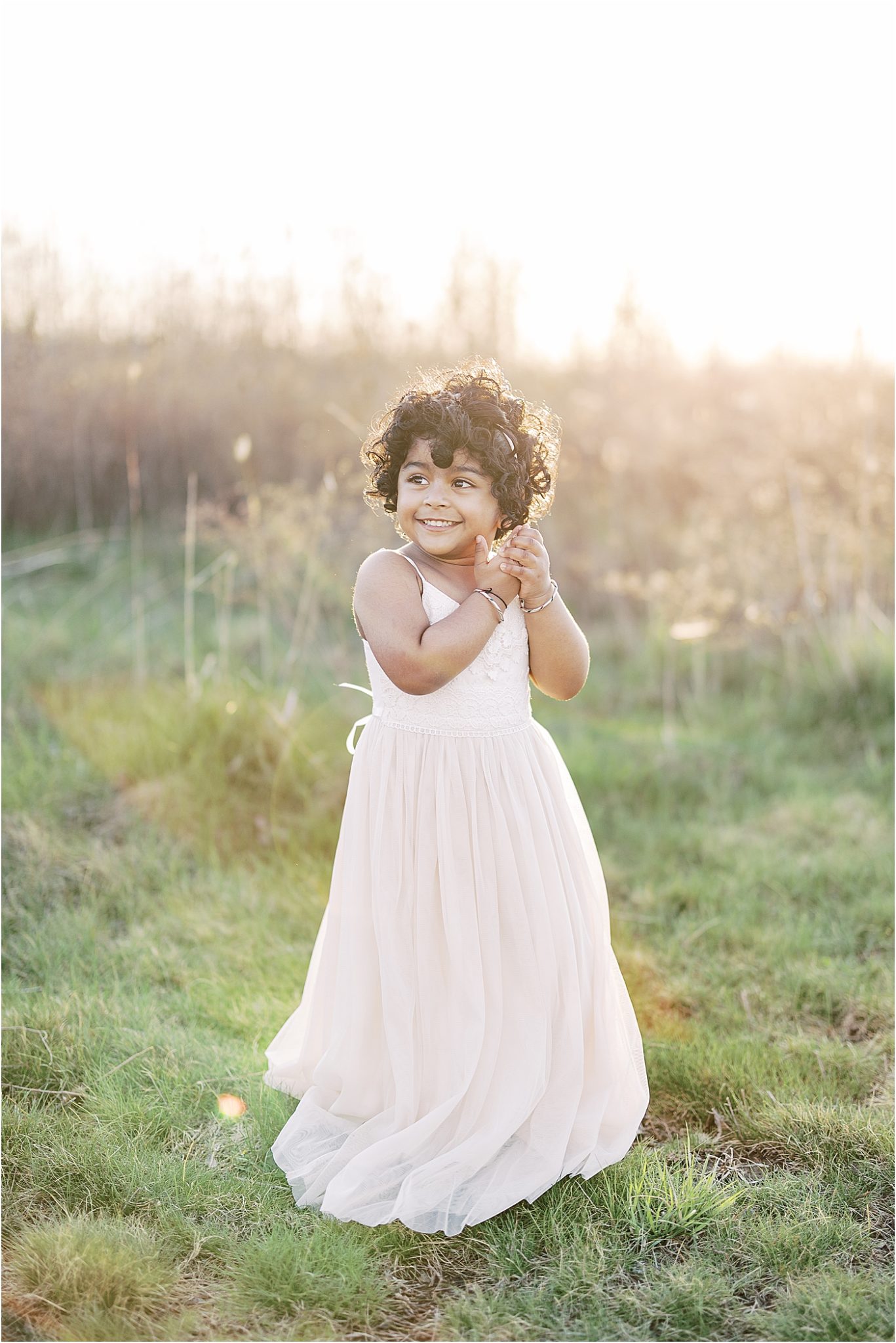 Young toddler girl in a beautiful dress during sunset. Photo by Lindsay Konopa Photography, natural light photographer in Indy.