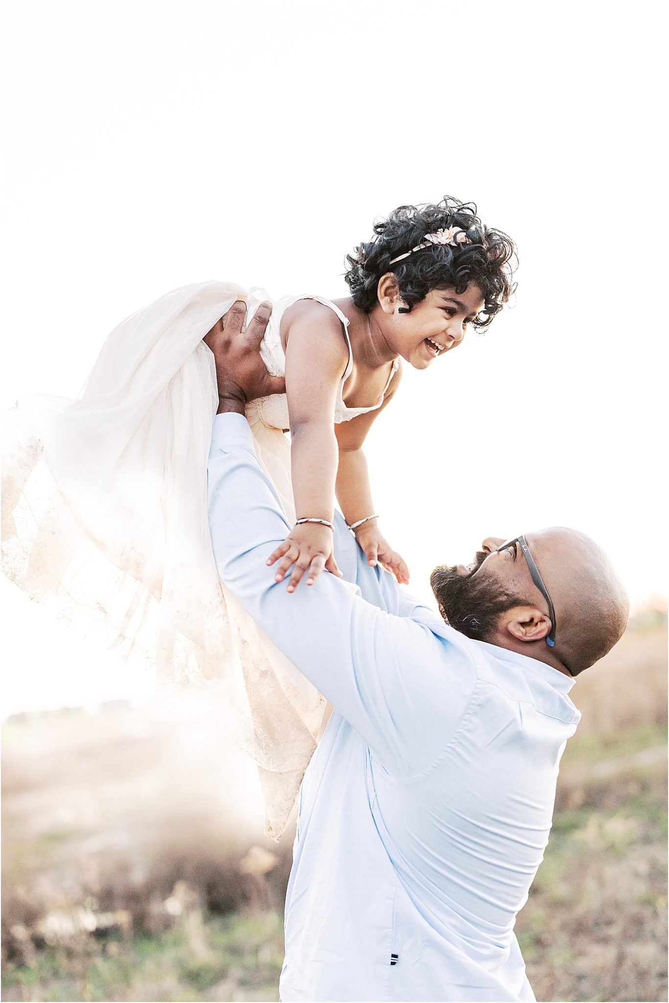 Daddy playing airplane with his daughter during family photoshoot. Photo by Lindsay Konopa Photography.