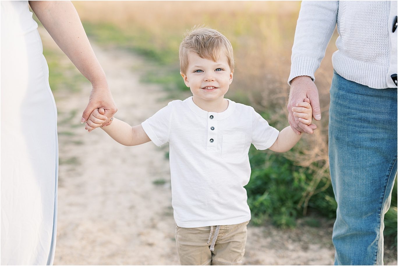 Young boy holding mom and dads hands | Lindsay Konopa Photography