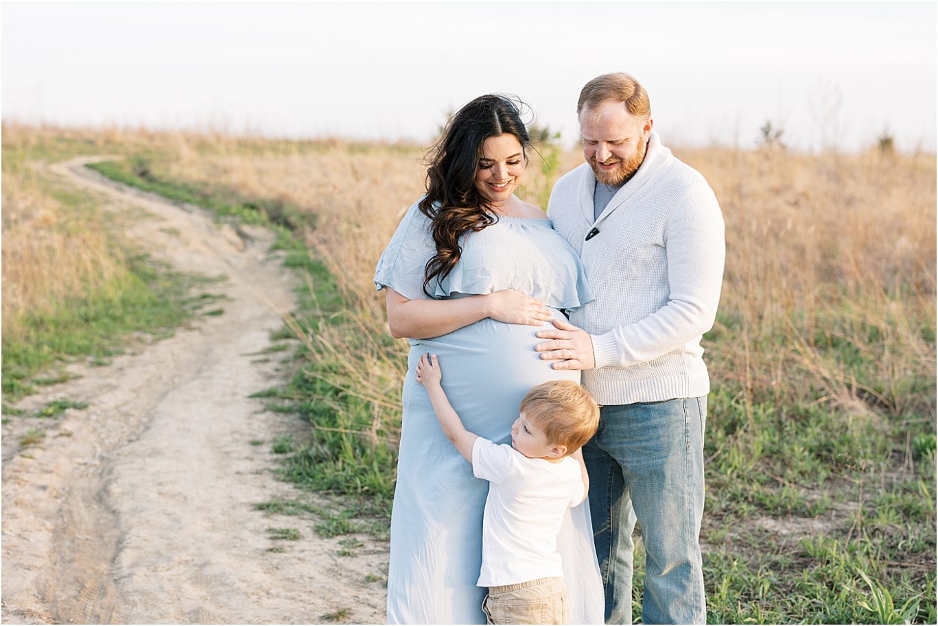 Mom and Dad looking at their oldest son as he hugs Mom's pregnant belly. Photo by Lindsay Konopa Photography.