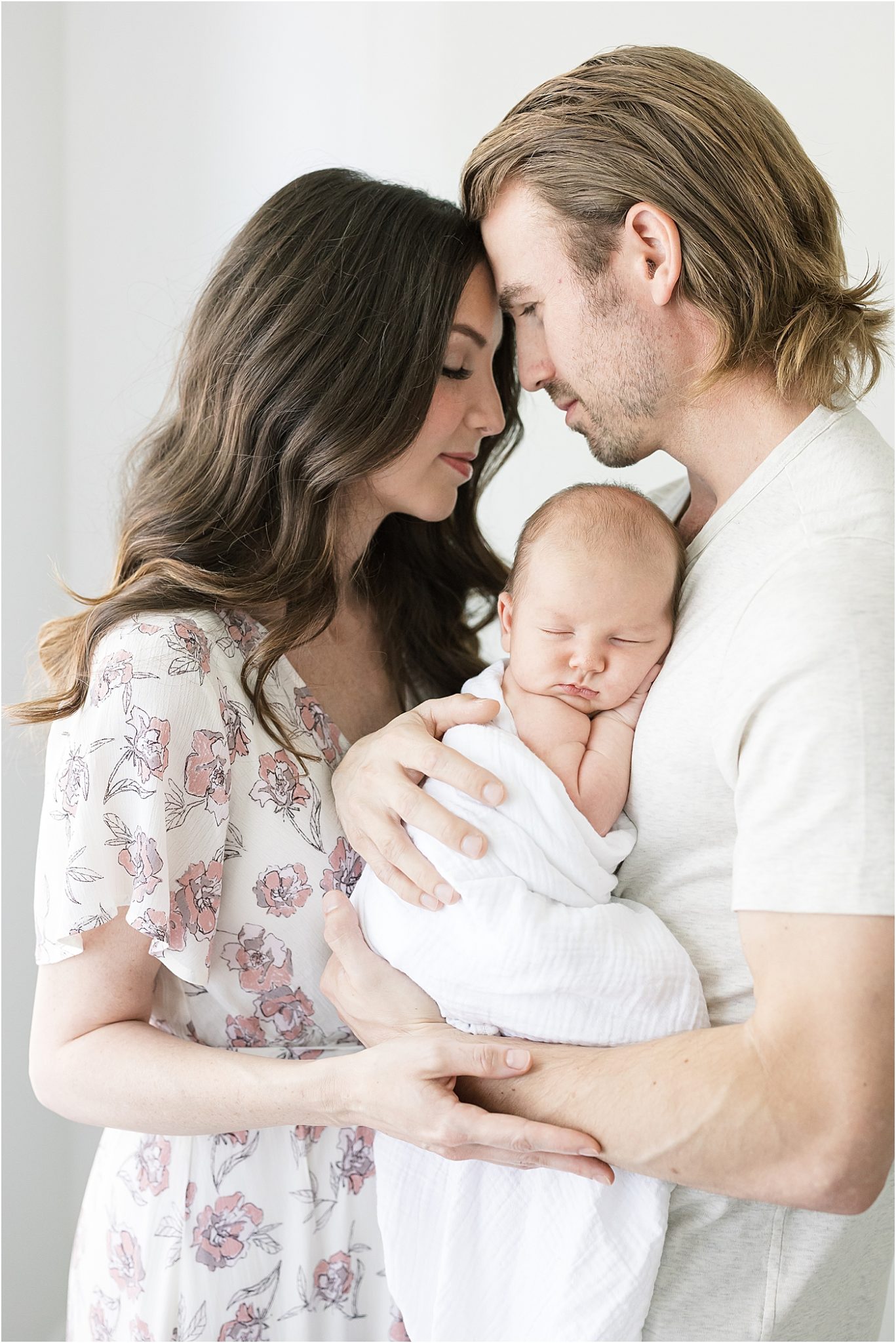 Mom and Dad sharing a sweet moment holding their son during newborn photos with Lindsay Konopa Photography.