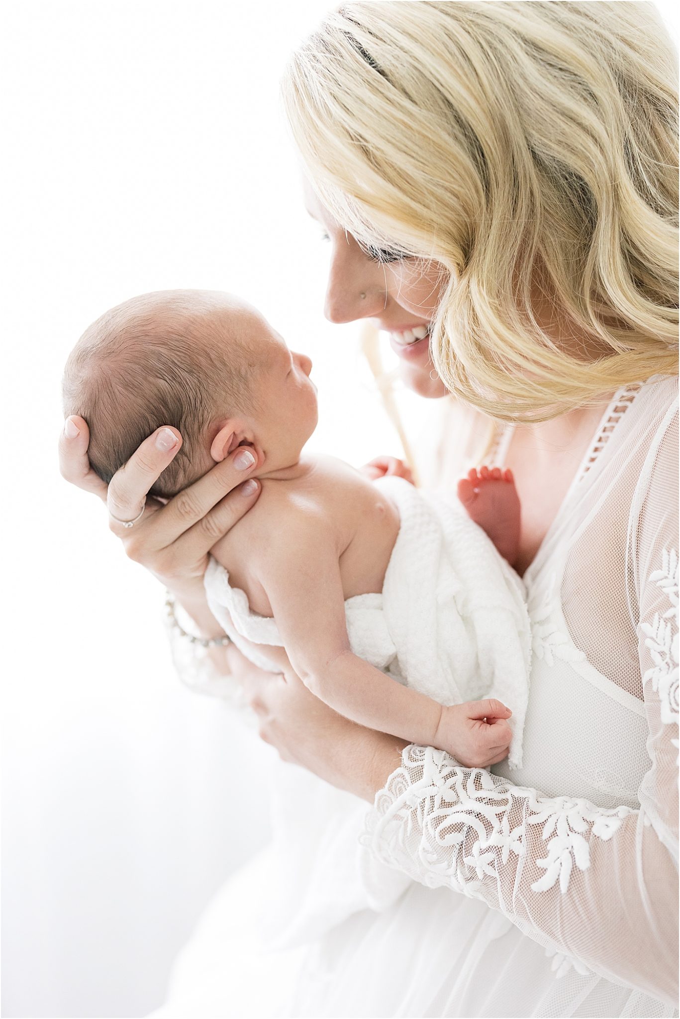 Mom holding baby boy for newborn photos in Indianapolis newborn studio. Photo by Lindsay Konopa Photography.