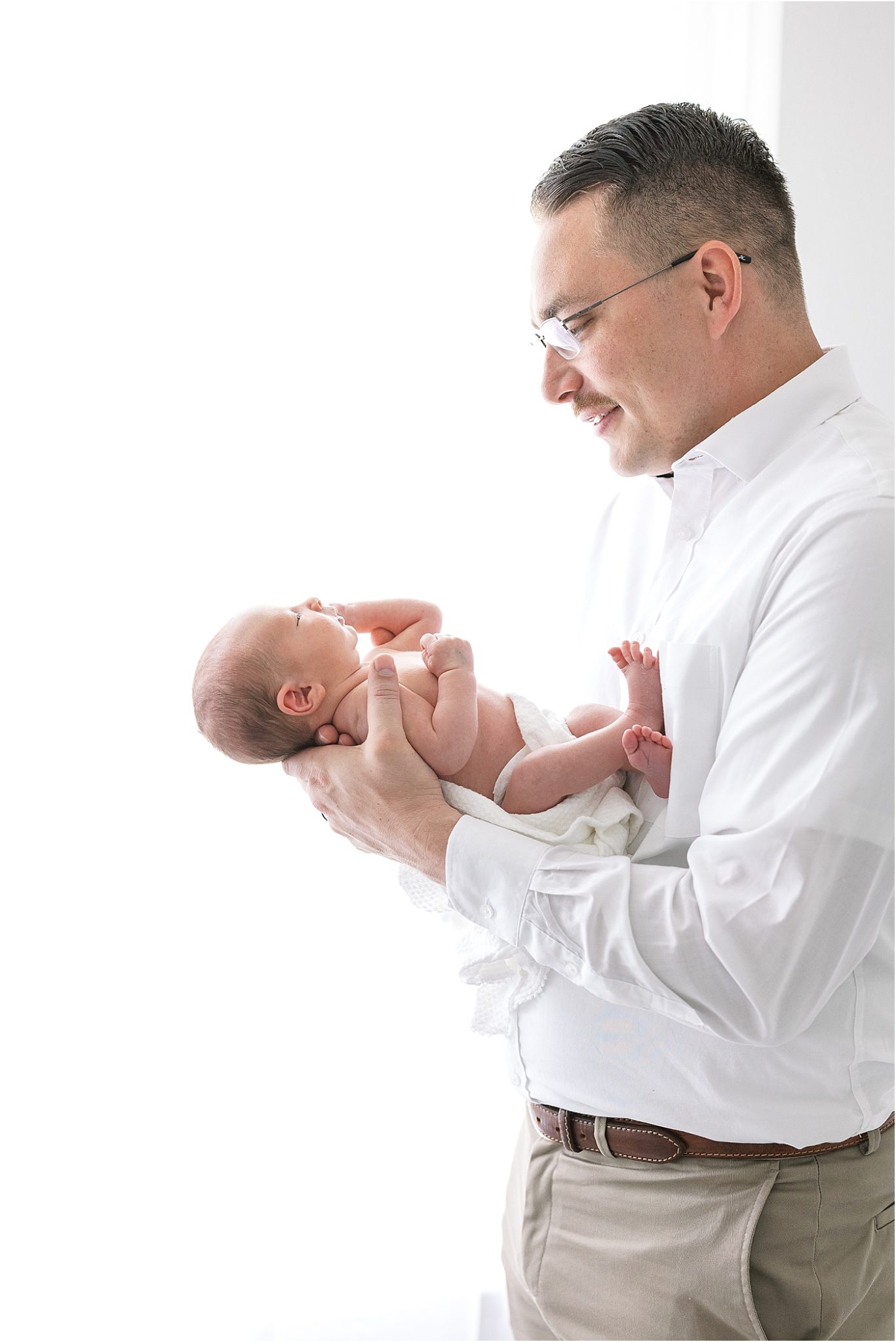 Dad holding son for newborn photos with Lindsay Konopa Photography.