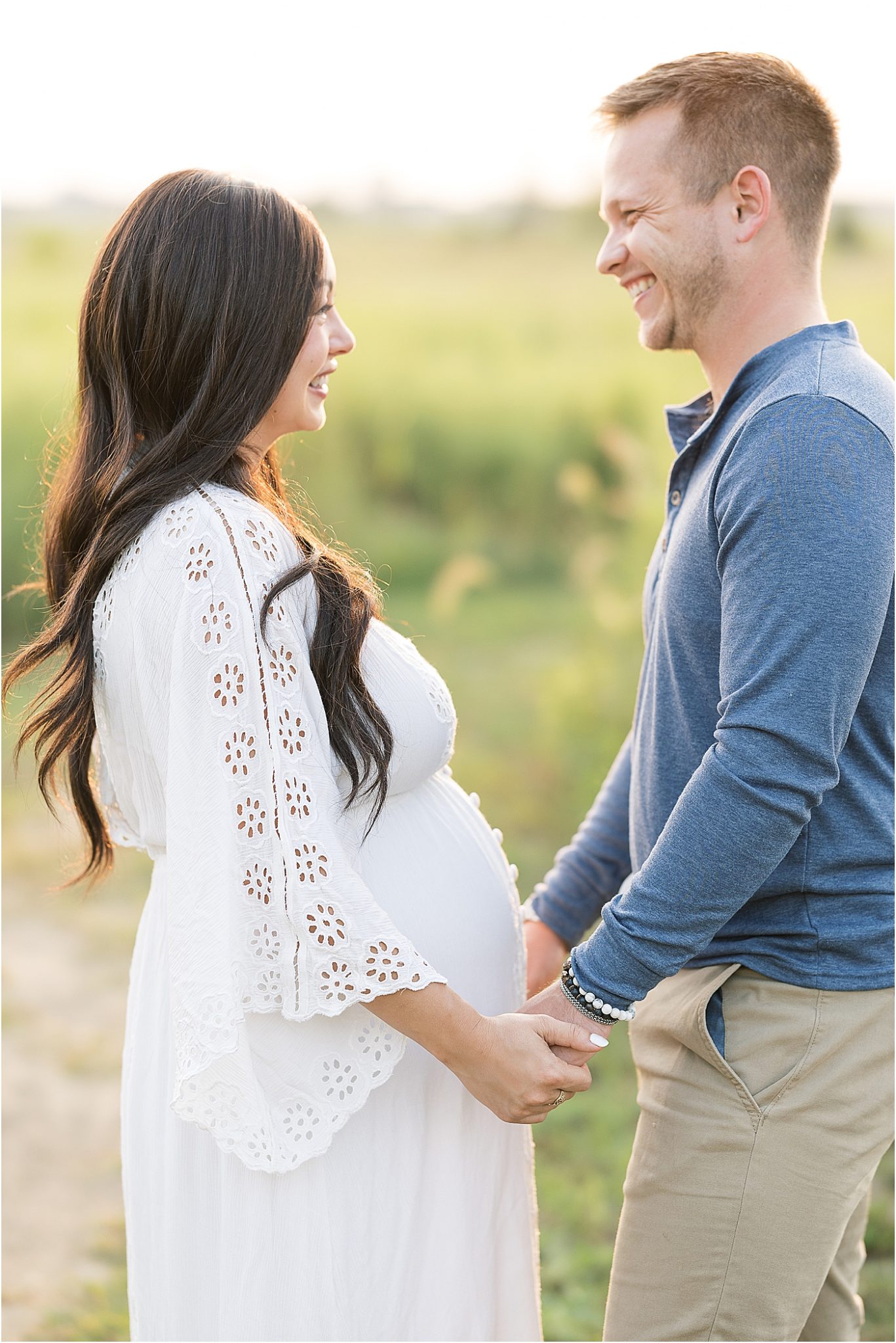 Parents-to-be looking at each other during outdoor maternity session | Photo by Lindsay Konopa Photography