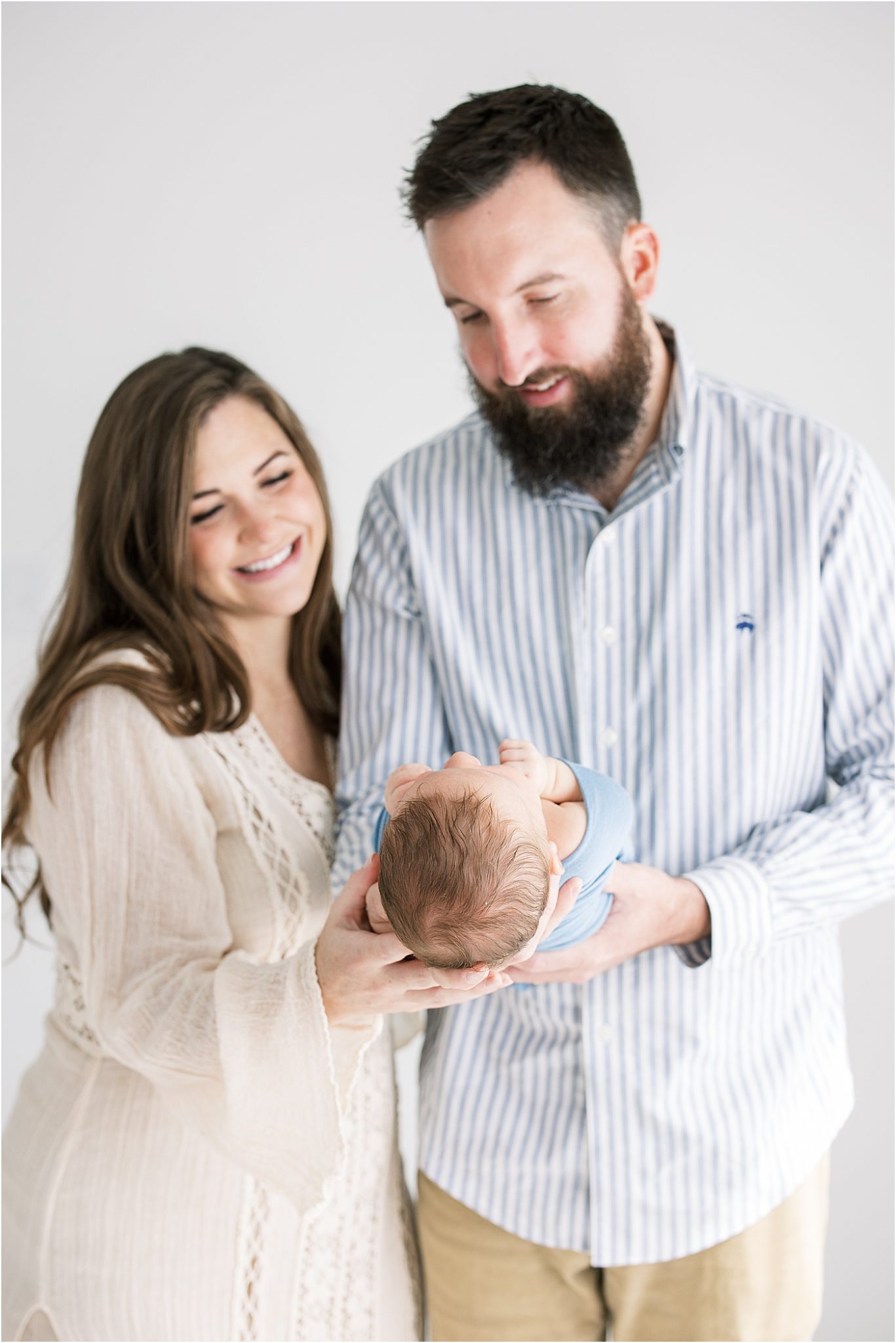 Parents looking at baby boy during newborn session in studio in Fishers with Lindsay Konopa Photography
