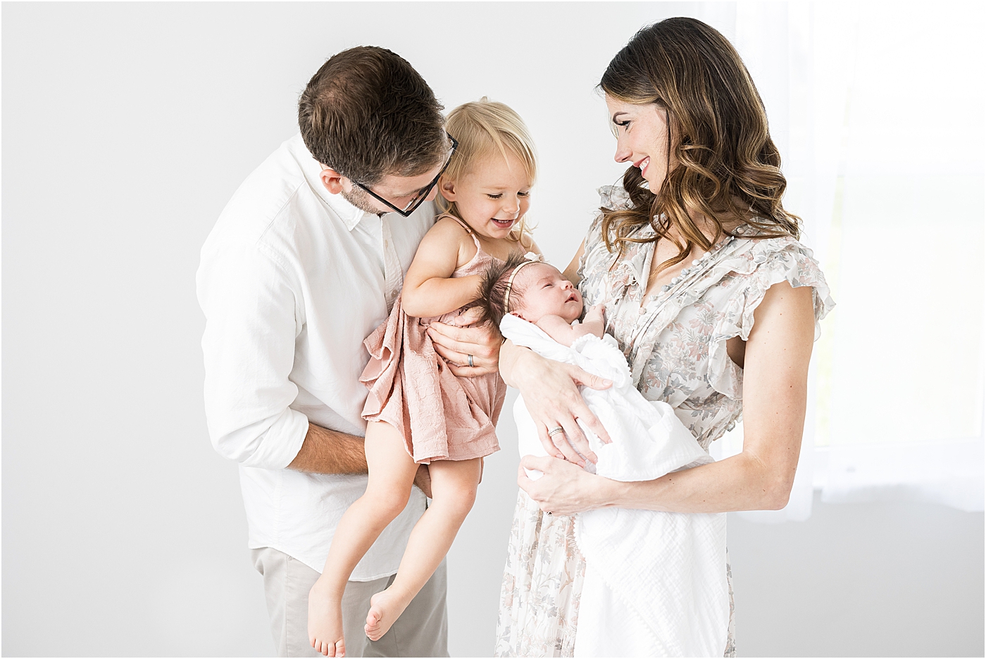 Family of four in studio for newborn photos with Fishers newborn baby photographer, Lindsay Konopa Photography.