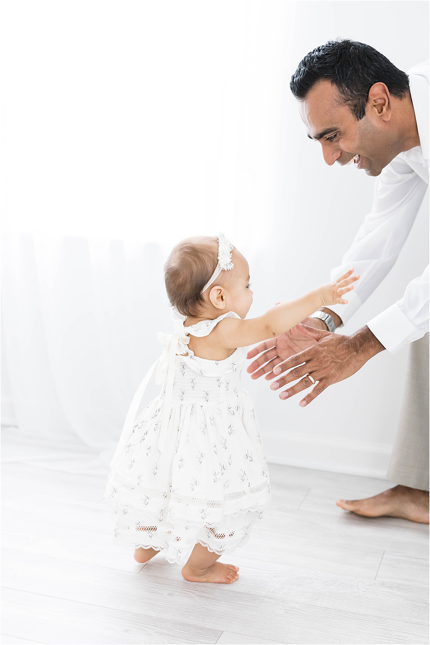 Dad reaching down to pick up his daughter | Lindsay Konopa Photography