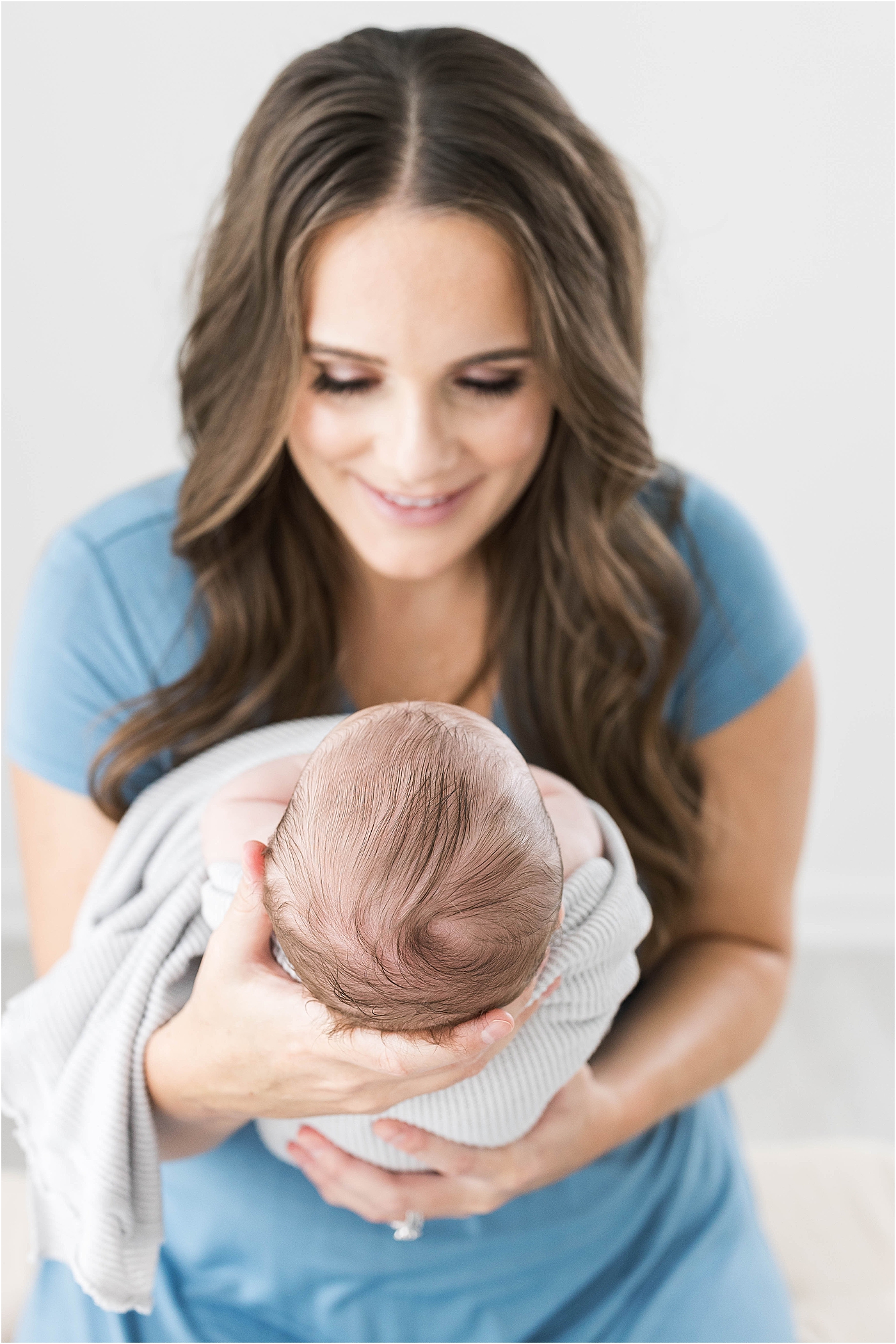 New mom holding baby out in front of her for newborn photos | Lindsay Konopa Photography