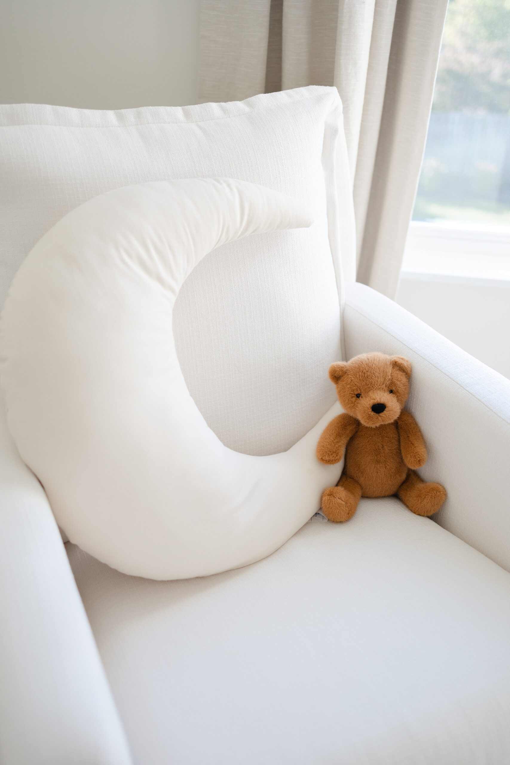 Details of a nursing chair with a moon pillow and stuffed bear